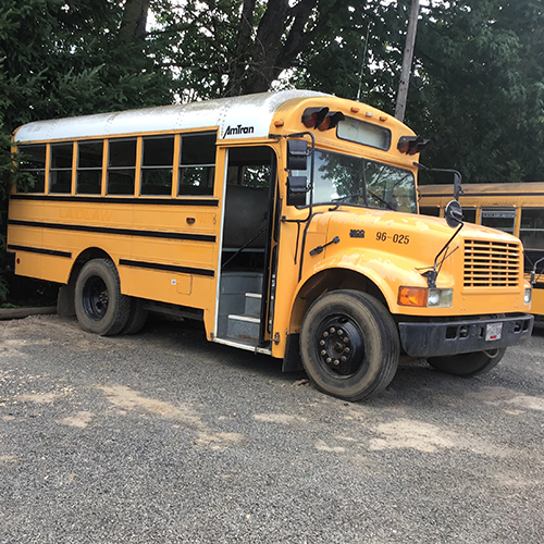 Yellow mini bus on gravel road