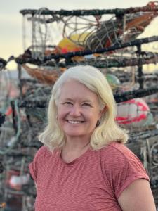 Picture of Marcy Harrington in front of crab pots on fishing dock